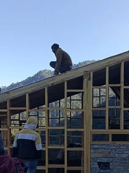 Artisans work on the roof structure of a guesthouse in Vasudev. The precision of the timber joinery is crucial for the building's stability and longevity, especially in a region with such a demanding climate.