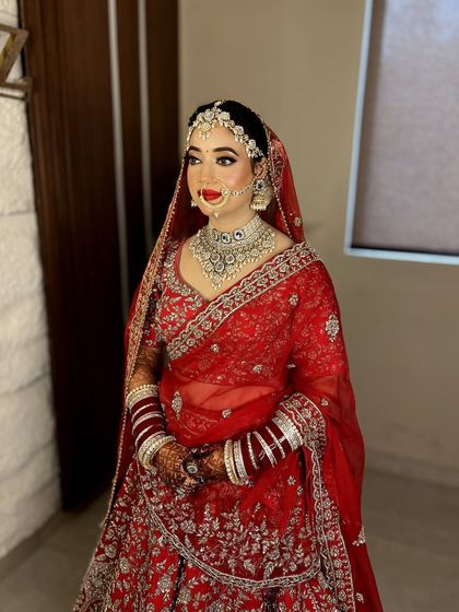 A full view of this traditional bride. The red lehenga, the intricate jewellery, and the bold makeup all come together for a breathtaking look.