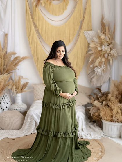A serene portrait of the mom-to-be in a beautiful olive green gown. The color looks stunning against the earthy tones of our rustic studio set.
