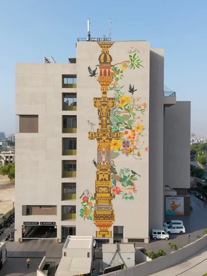 Our work often becomes a landmark for the city itself. This multi-story mural, 'The Tower of Harmony,' wraps the HCG Multispeciality Hospital in Ahmedabad, serving as a tribute to the city's heritage and ecological balance. We designed this vertical pillar as a symbolic 'stambh' or tower of values, blending traditional Indian temple architecture with contemporary aesthetics to create public art that inspires.