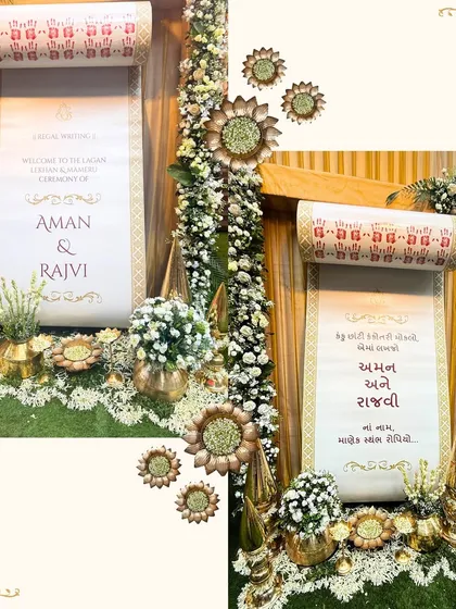 A personalized welcome scroll for the Kankotri Lekhan ceremony of Aman and Rajvi. This custom detail, surrounded by brass props and florals, adds a unique and personal touch to the event.