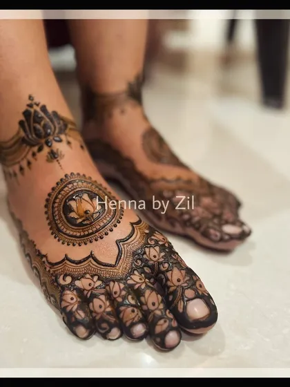 An elegant and intricate foot design featuring a central lotus mandala. This was created to match the bride's symmetrical hand mehendi.