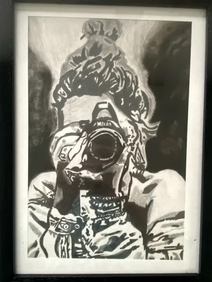 A powerful charcoal self-portrait of an artist with their camera, created by a student in our sketching and shading course.