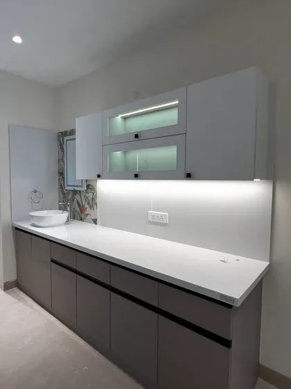 This custom crockery unit features a mix of closed and glass-front cabinets with internal lighting, providing both storage and a display area.
