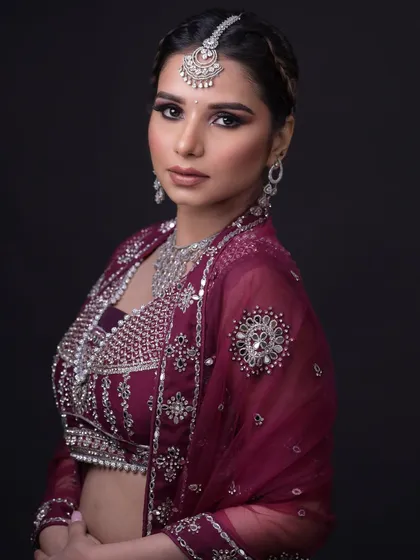 A glamorous reception look with a deep purple lehenga and diamond jewelry. The smokey eye adds drama.