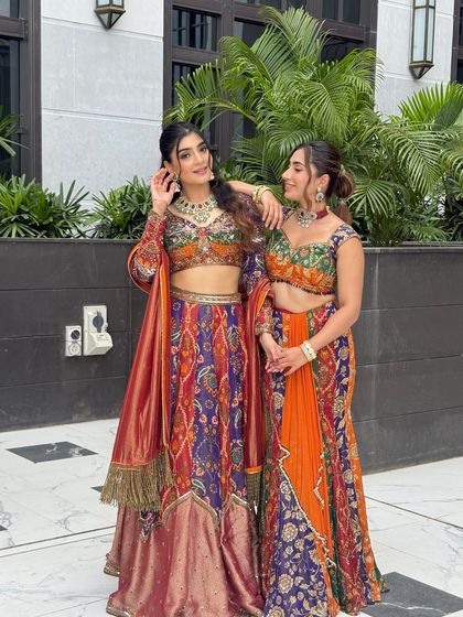 A fun and loving pose between the sisters, showcasing their coordinated yet individual styles for the wedding event.