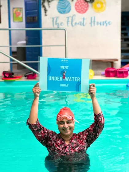 Conquering fears and making waves. This member proudly holds a sign showing she went underwater today, a huge step in her swimming journey.