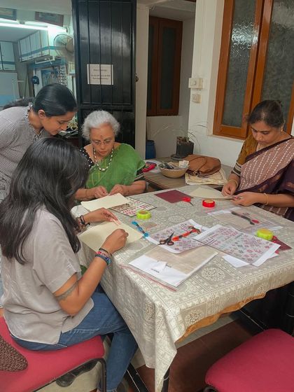 A Kasuti workshop in full swing. Students are gathered around the table, learning the intricate counted-thread technique together.