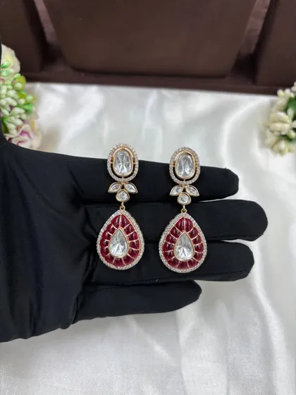 A close-up of the earrings from the red meenakari drop polki set.