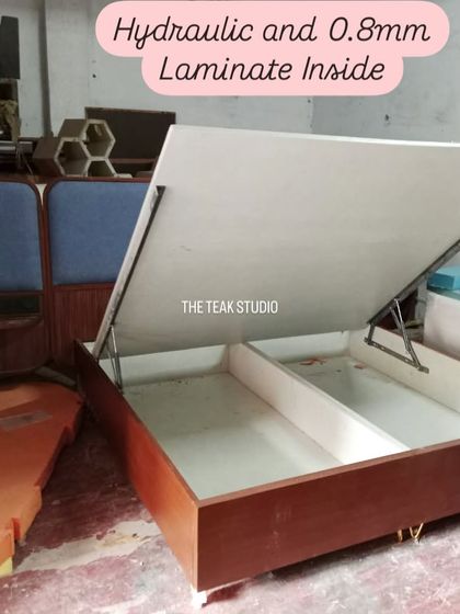 A view of a hydraulic bed frame under construction in my workshop. You can see the sturdy mechanism and the clean laminate finish I use for the interior storage box.