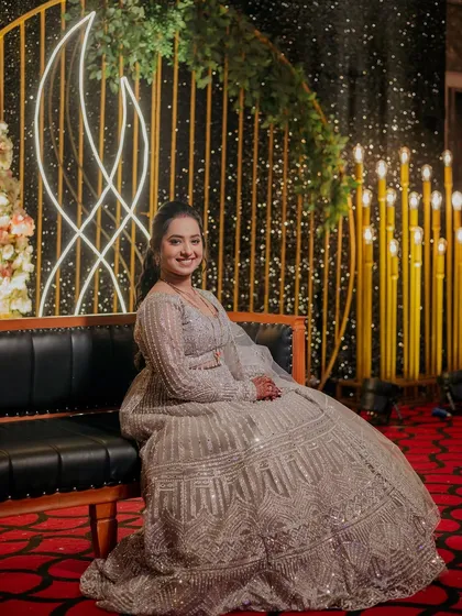 A full-length portrait of the bride seated, her gorgeous lehenga spread out around her.