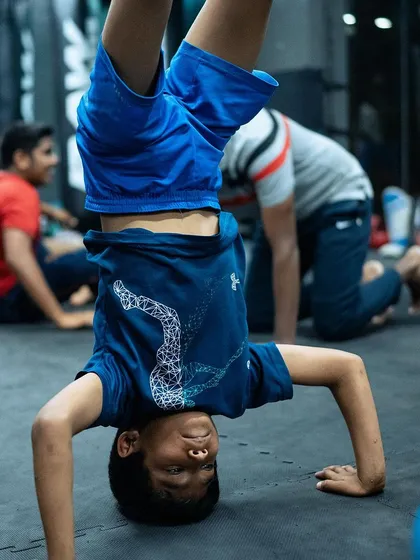 Training should also build agility and body control. A young student has some fun with a handstand, developing core strength and balance in between drills.