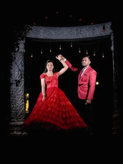 A dramatic, low-light shot of a couple dancing, framed by the stone gazebo.