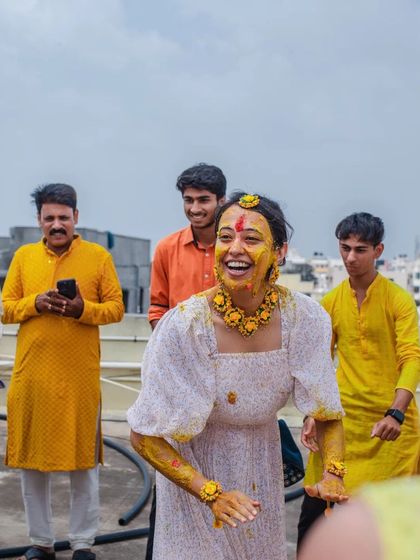 A duplicate of 126, a candid shot of the bride laughing during her Haldi.
