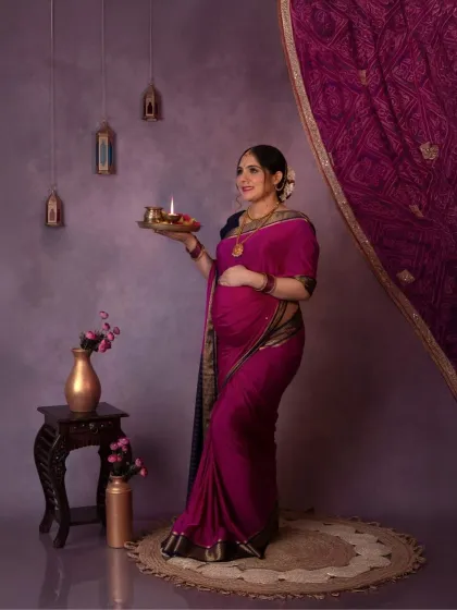 A solo portrait of the mama-to-be holding a diya, a symbol of light and hope. Her expression is serene and full of grace.
