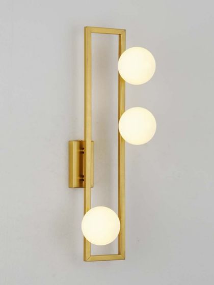A linear wall sconce with three frosted globes inside a rectangular brass frame. A clean, geometric design for modern spaces.