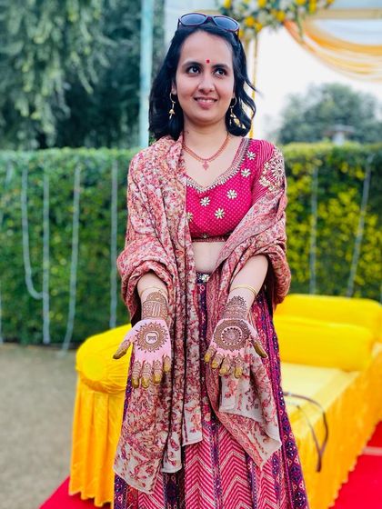 A happy client at a mehndi function, proudly showing her beautiful mandala designs. Her smile says it all.
