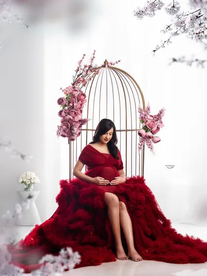I offer unique, creative setups like this beautiful birdcage prop to make your photos stand out. Paired with a dramatic red ruffled gown, it creates a fairytale-like scene for a truly memorable maternity portrait.