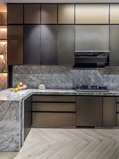 Our kitchen designs merge high-end functionality with flawless aesthetics. This space features waterfall marble countertops, handleless cabinetry for a sleek finish, and integrated appliances, complemented by a herringbone wooden floor.