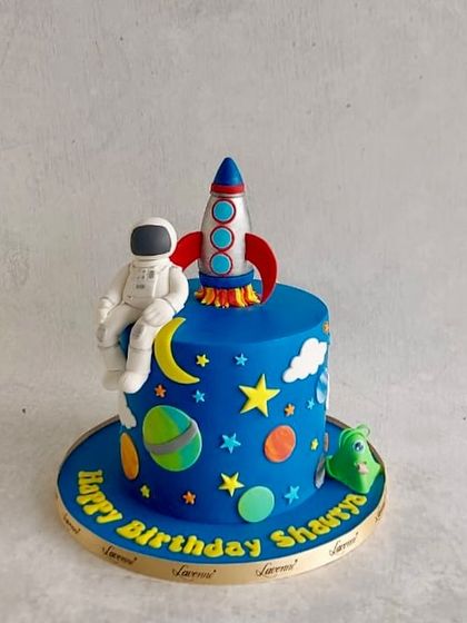 An astronaut and rocket ship cake for Shaurya's birthday. A fun space theme with planets and stars.