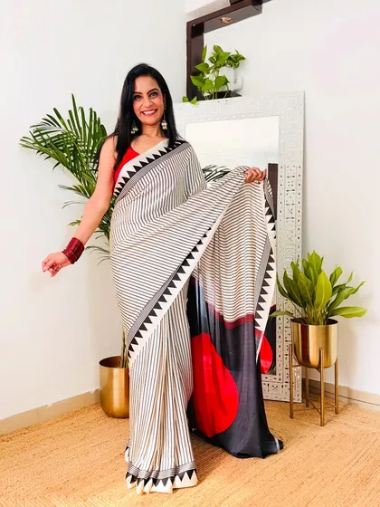 I love the modern, abstract print on this black, white, and red satin saree. It's a unique and eye-catching piece for anyone who wants to stand out at a party.