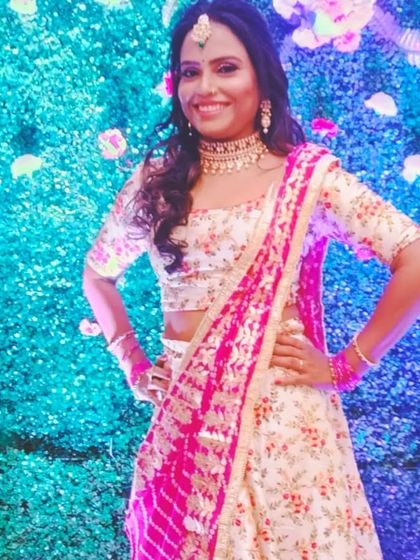 Posing against a vibrant backdrop, this client shows off her floral lehenga and the rented jewellery that completes her look.