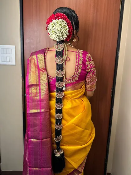 A beautiful South Indian bridal braid adorned with traditional `Jada` billai, the series of gold discs that run down the length of the braid. The look is completed with fresh flowers.