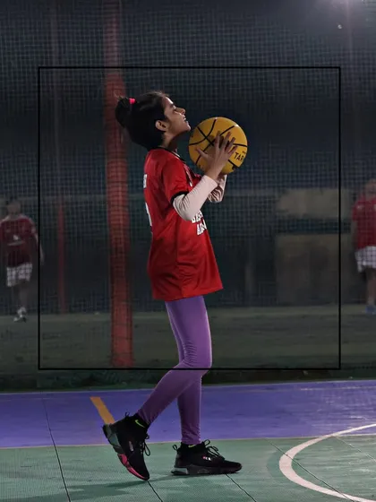 A young girl prepares to shoot, showing her focus and determination. We create a space where every player can grow and feel motivated.