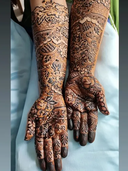 A full floral bridal henna design that is both bold and delicate. The contrast between the filled-in flowers and the finer line work creates a beautiful effect.