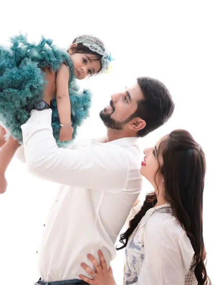 A moment of flight. This angelic shot of a father lifting his daughter is made even more magical by her beautiful teal dress, contrasting with the clean white background.