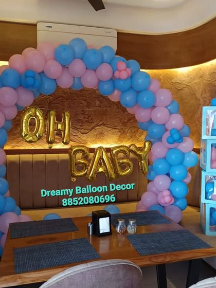 An 'Oh Baby' balloon arch set up over a table in a restaurant. This shows how I can decorate any venue for your baby shower celebration.