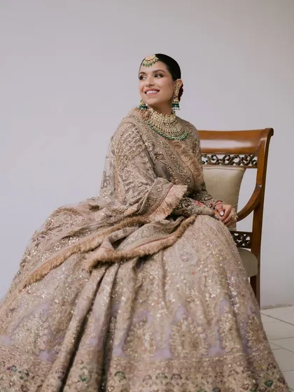 A full-length shot capturing Avika's complete bridal look. Her soft, glowing makeup perfectly complements the intricate details of her Rimple and Harpreet lehenga.
