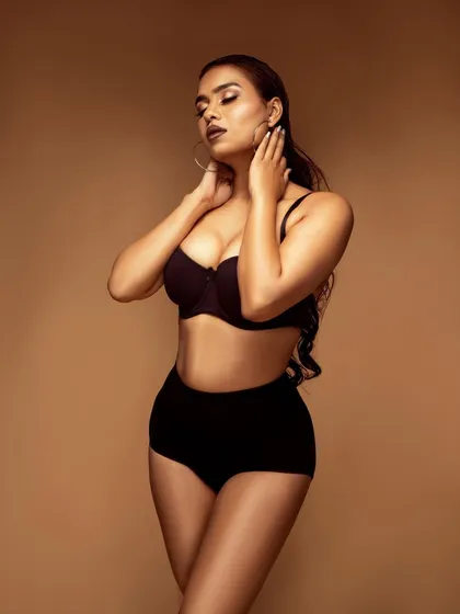 A pose that highlights the model's curves and the fit of the lingerie, creating an image that is both strong and sensual.