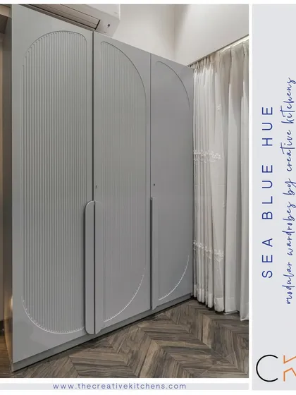 Our modular wardrobe in a calming sea blue hue features intricate fluted shutters with a European membrane finish. The arched design and integrated handles create a statement of impeccable, modern design.
