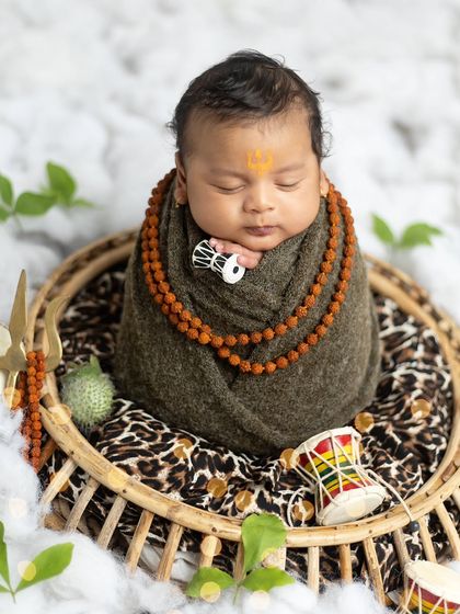 This little one is holding a miniature damaru, a playful yet divine touch to the Mahadev theme.