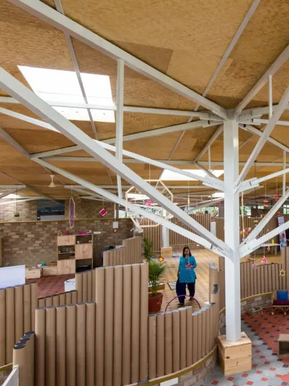 These images showcase the interior of the Atelier school, where partitions are made from recycled paper tubes. This innovative material choice is not only sustainable but also creates a playful, maze-like environment that encourages exploration and imaginative play.