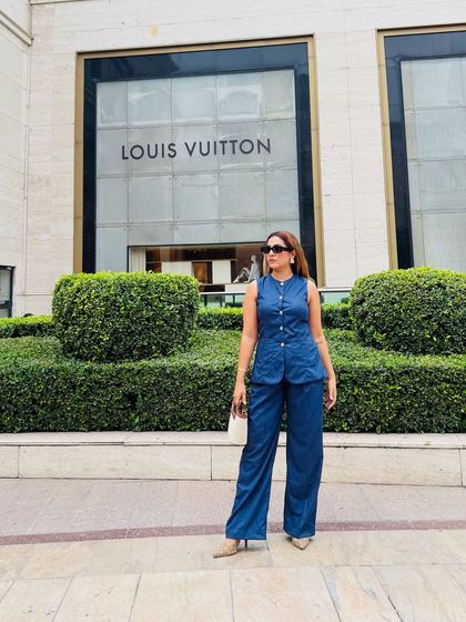 A full view of the denim co-ord set, showcasing its modern and powerful silhouette. Paired with a neutral bag and pointed heels, it's a touch of luxe without being too loud.