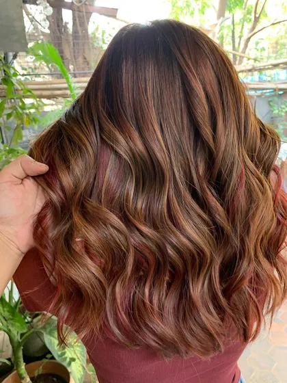 A rich and soft chestnut brown with slivers of red woven through. This look was created on previously lightened hair without using any new bleach.