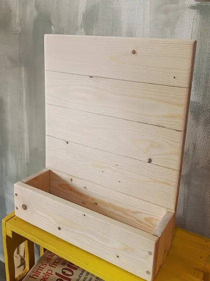 The "Kanasu" name plaque before the painting process begins, showing the raw, natural beauty of the solid pine wood structure we build by hand.