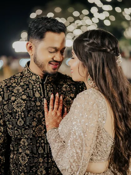 An intimate moment between the couple. Her soft, sparkling makeup looks stunning under the evening lights.