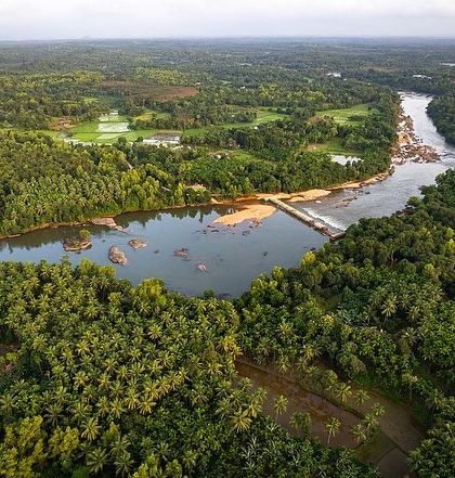 A drone's view of the lush green landscape where a river winds through the forests near Udupi. It shows a different side of coastal life, away from the beaches.