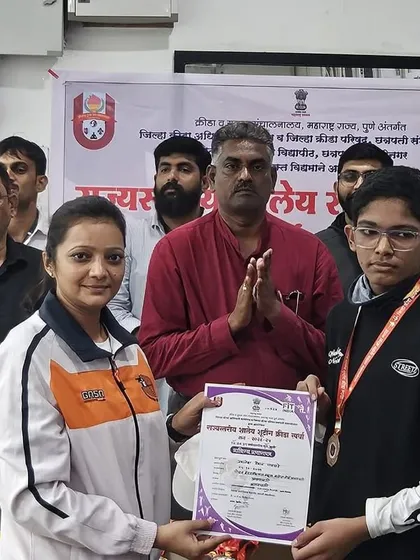 A young shooter receiving his medal at the state tournament. I ensure my coaches are present to support our athletes during these important events.