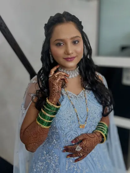 My client looking lovely in a powder blue gown, perfect for a reception. Her makeup is soft and pretty, with open curls and a diamond necklace.