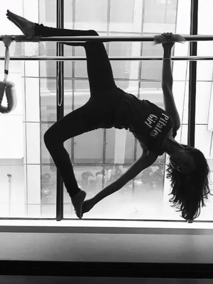 A black and white shot of a graceful inversion on the Cadillac. This artistic photo captures the beauty and control inherent in Pilates.