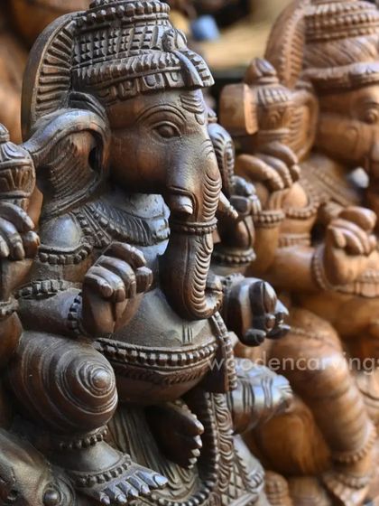 A detailed shot of two Ganesha idols, allowing a comparison of their facial expressions and ornamentation.