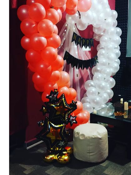 A Halloween-themed movie night setup. I can customize the decorations for any theme, including spooky season with orange and white balloons and star-shaped props.