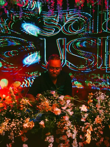 Another perspective from the Masala House launch, with the trippy visuals in the background. My setup is surrounded by flowers, adding to the unique theme of the night.