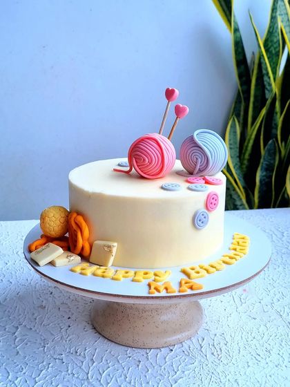 A full view of the knitting and sweets-themed 80th birthday cake.