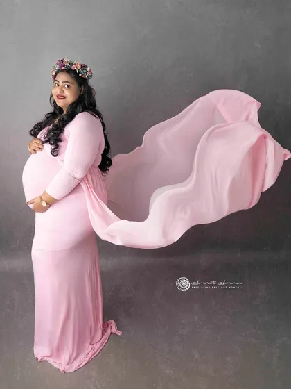 Capturing movement and grace. The flowing fabric of the gown adds a dynamic and artistic element to this portrait, making the image feel alive and full of energy.