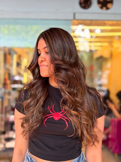 Fresh color vibes unlocked. This is another look at our popular caramel and chocolate brown balayage, styled into beautiful, bouncy curls that show off the color's dimension.